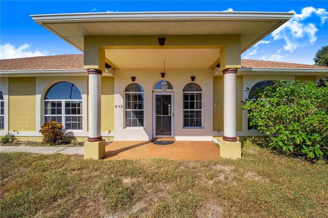 view of exterior entry featuring a yard