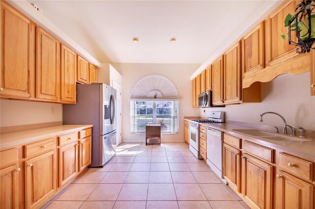 kitchen featuring light tile patterned floors, stainless steel appliances, and sink