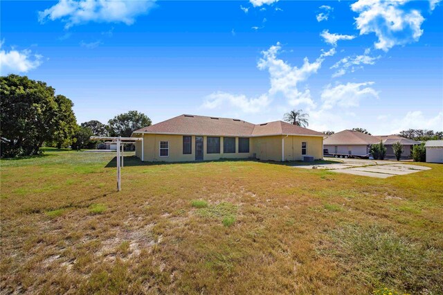 rear view of property featuring a yard