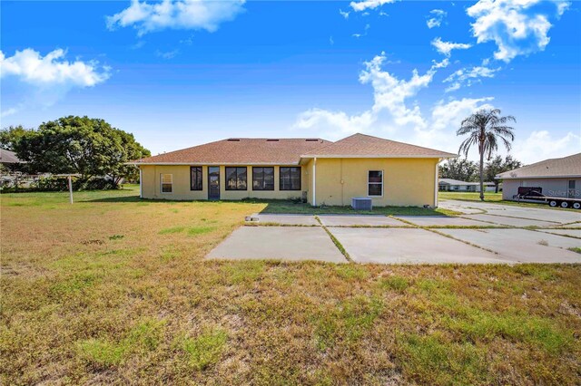 rear view of property featuring a yard, a patio area, and central air condition unit