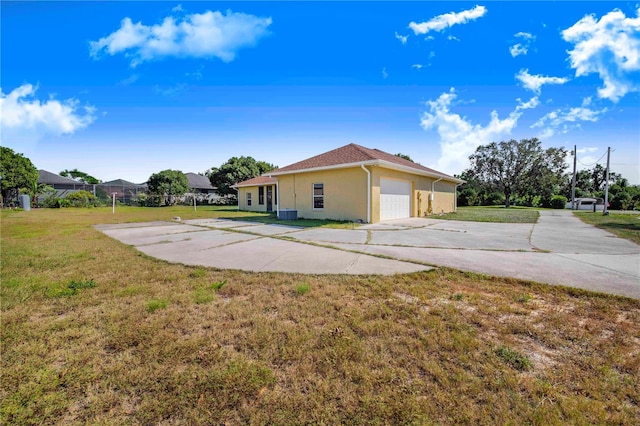 view of side of property featuring a garage and a lawn