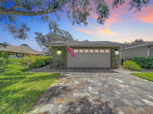 view of front of house with a garage and a lawn