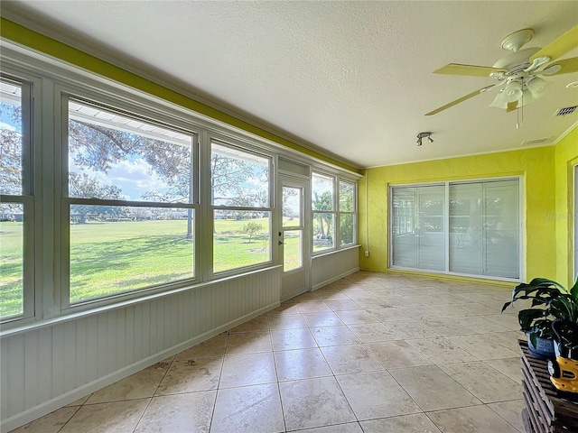 unfurnished sunroom with a wealth of natural light and ceiling fan