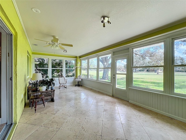 unfurnished sunroom with ceiling fan