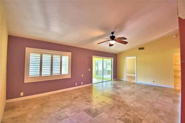 unfurnished room with a textured ceiling, vaulted ceiling, and a healthy amount of sunlight