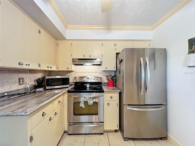 kitchen with appliances with stainless steel finishes, tasteful backsplash, cream cabinets, ornamental molding, and light tile patterned flooring