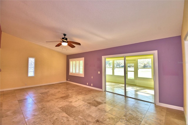 spare room with lofted ceiling, a textured ceiling, and ceiling fan