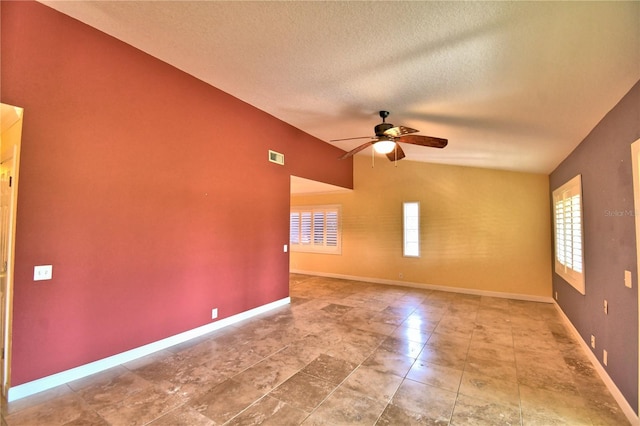 unfurnished room featuring ceiling fan, vaulted ceiling, and a textured ceiling