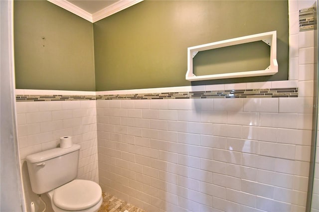 bathroom with tile walls, ornamental molding, and toilet