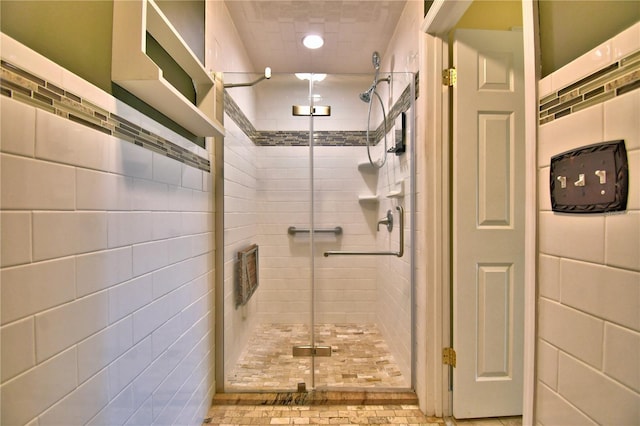 bathroom with an enclosed shower and tile walls