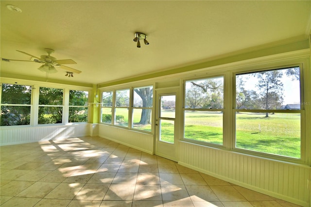 unfurnished sunroom with ceiling fan