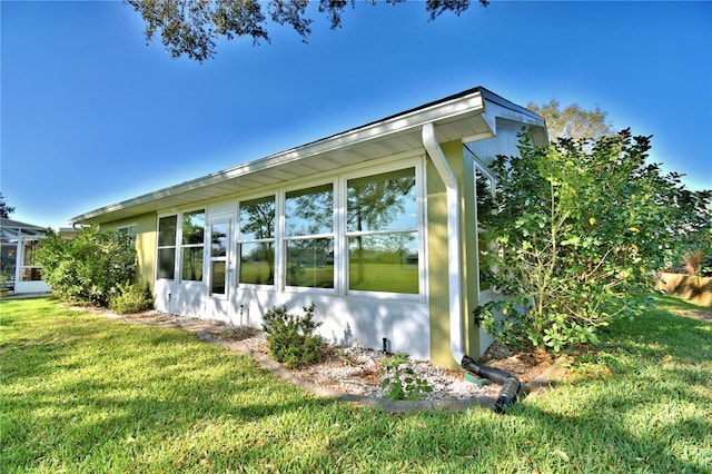 view of side of home with a yard