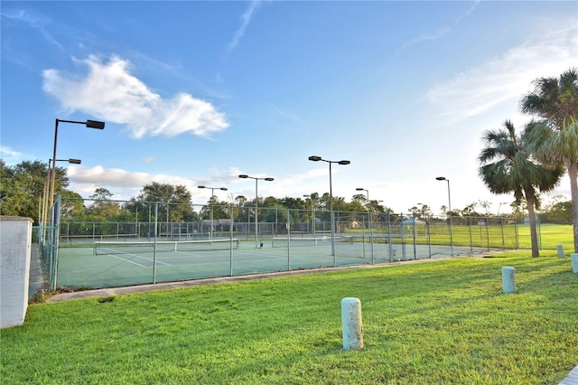 view of sport court featuring a lawn