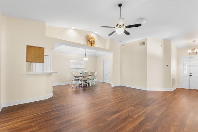 unfurnished living room featuring vaulted ceiling, dark hardwood / wood-style floors, and ceiling fan with notable chandelier