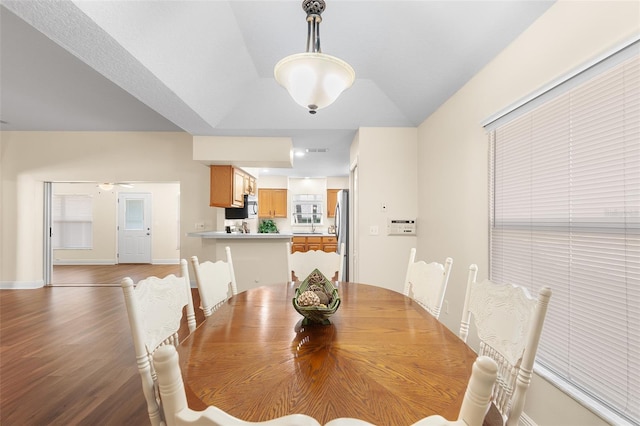 dining area featuring ceiling fan, light wood-type flooring, and vaulted ceiling