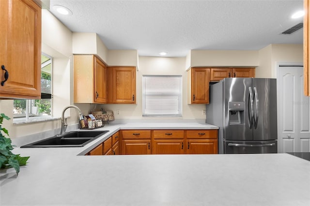 kitchen featuring sink, stainless steel fridge, and a textured ceiling