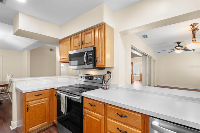 kitchen featuring kitchen peninsula, appliances with stainless steel finishes, ceiling fan, and dark hardwood / wood-style flooring