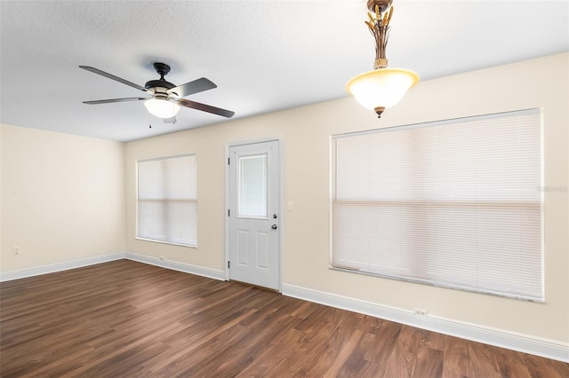 foyer featuring a textured ceiling, dark wood-type flooring, and ceiling fan