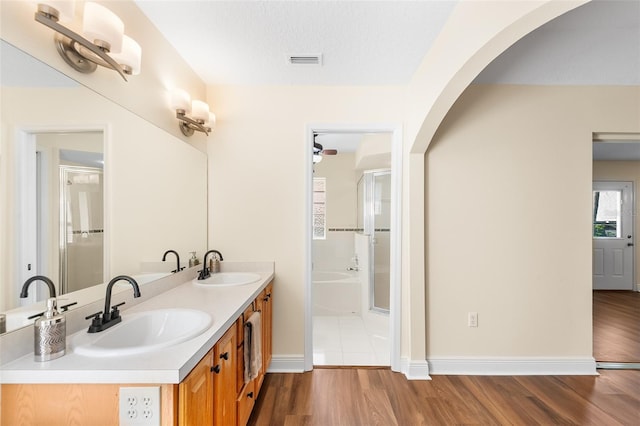 bathroom featuring hardwood / wood-style floors, independent shower and bath, vanity, and a textured ceiling