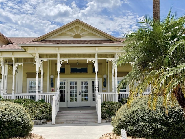 property entrance featuring covered porch and french doors