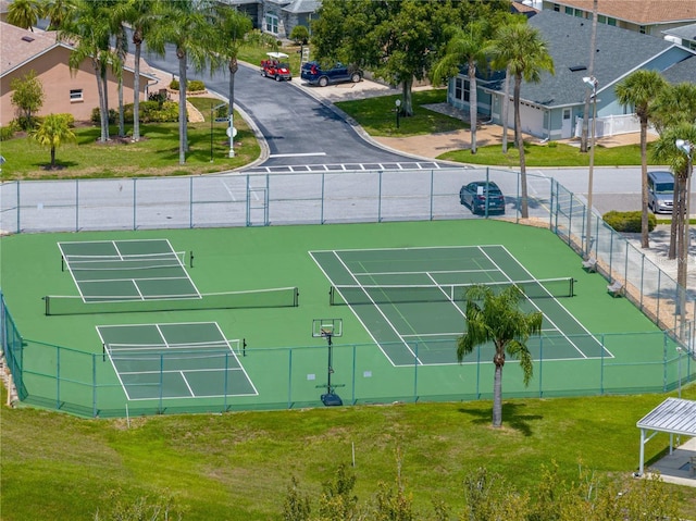 view of sport court with a lawn