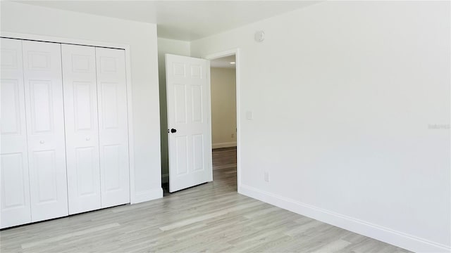 unfurnished bedroom featuring light hardwood / wood-style floors and a closet