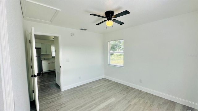 empty room with ceiling fan and light wood-type flooring