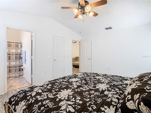 bedroom with lofted ceiling, connected bathroom, and ceiling fan