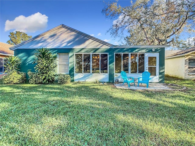 back of property with a patio area and a lawn