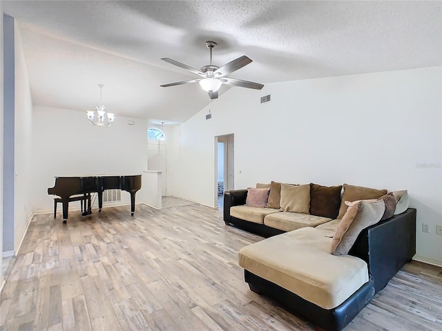 living room featuring light wood-type flooring, vaulted ceiling, a textured ceiling, and ceiling fan with notable chandelier