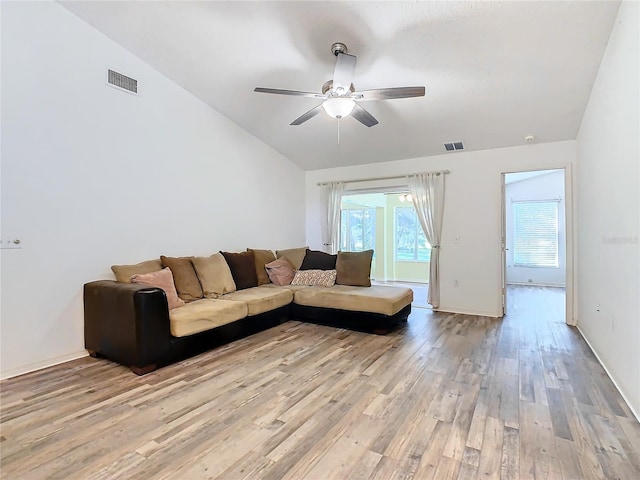 living room with ceiling fan, light wood-type flooring, and vaulted ceiling