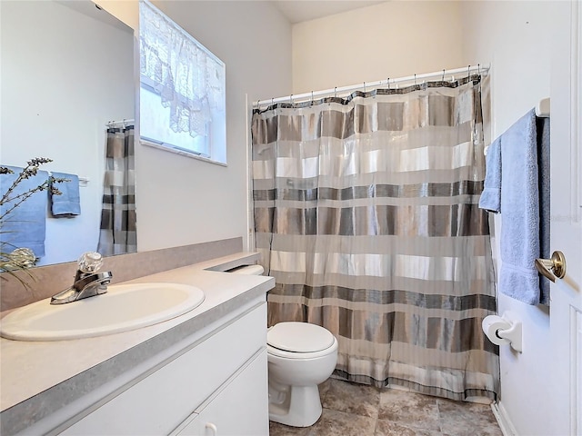 bathroom featuring toilet, vanity, and walk in shower