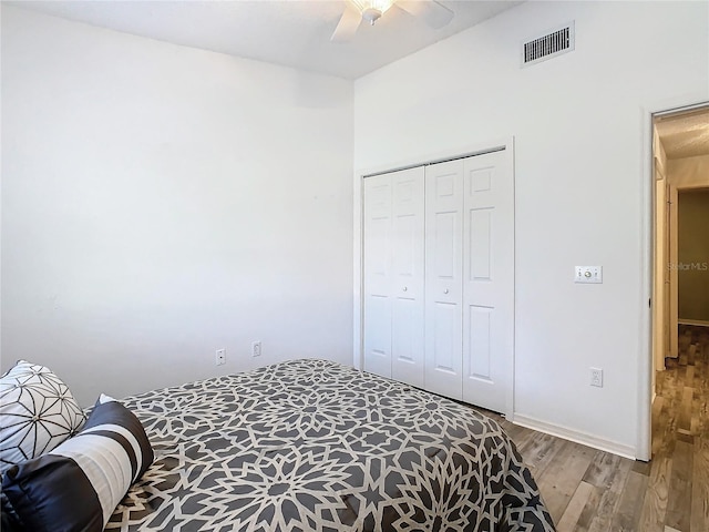 bedroom with ceiling fan, light wood-type flooring, and a closet