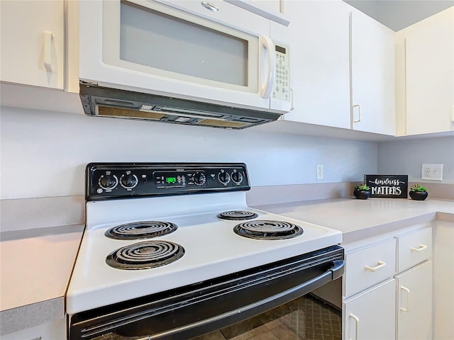 kitchen featuring electric range oven and white cabinets