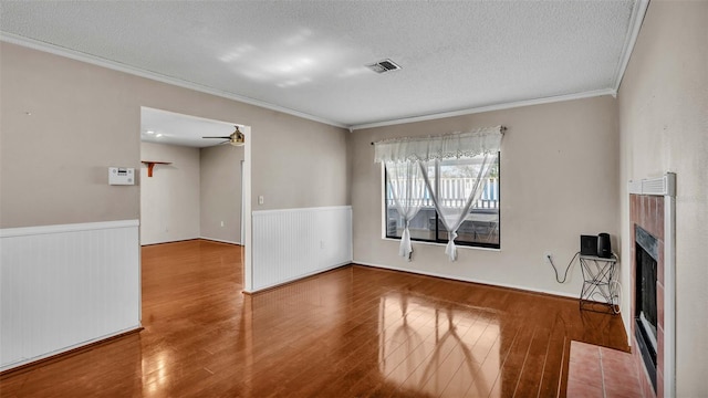 unfurnished living room featuring hardwood / wood-style floors, crown molding, a textured ceiling, and ceiling fan