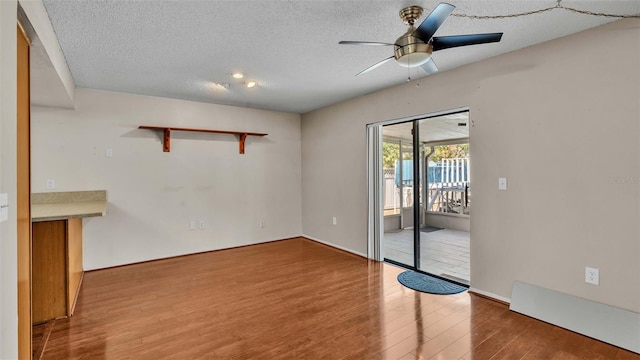 unfurnished room featuring hardwood / wood-style floors, a textured ceiling, and ceiling fan