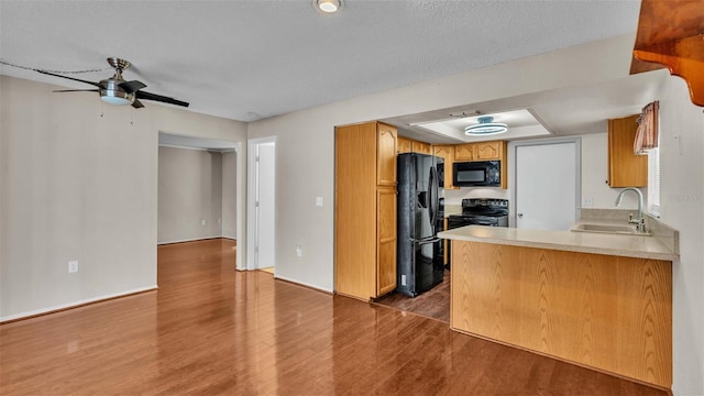 kitchen with sink, ceiling fan, black appliances, and dark hardwood / wood-style flooring