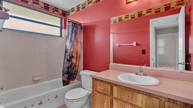 full bathroom with vanity, toilet, shower / bathtub combination with curtain, and plenty of natural light