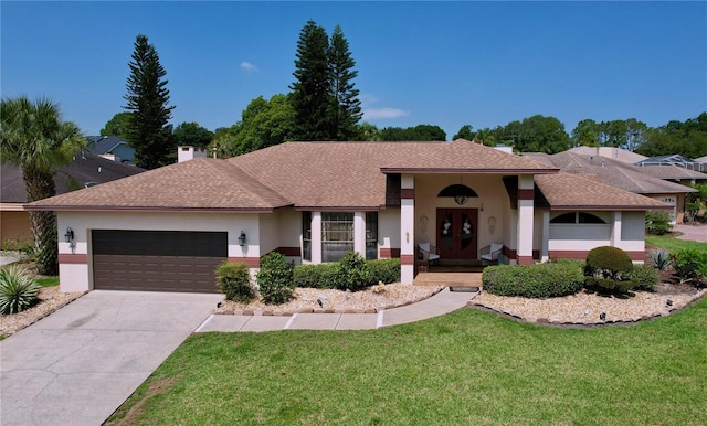 ranch-style home featuring concrete driveway, an attached garage, french doors, a front yard, and stucco siding