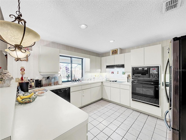 kitchen featuring light countertops, visible vents, white cabinetry, a sink, and black appliances