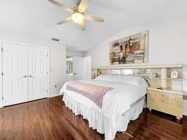 bedroom featuring a textured ceiling, a closet, ceiling fan, lofted ceiling, and dark hardwood / wood-style floors