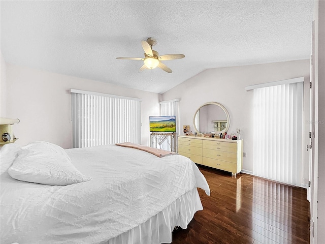 bedroom with a ceiling fan, lofted ceiling, dark wood-style flooring, and a textured ceiling