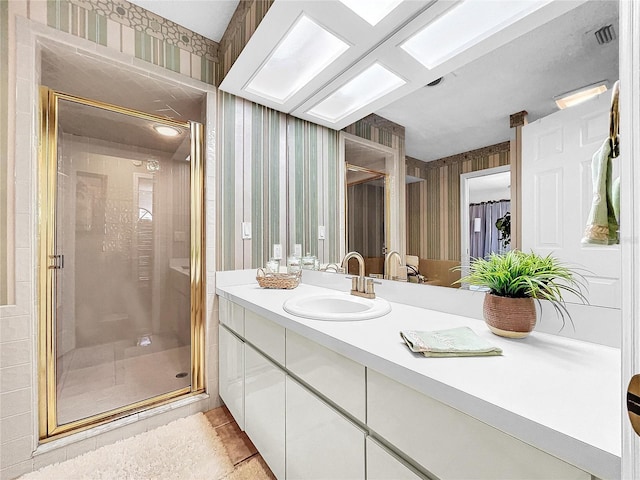 full bathroom with wallpapered walls, visible vents, tile patterned floors, vanity, and a shower stall