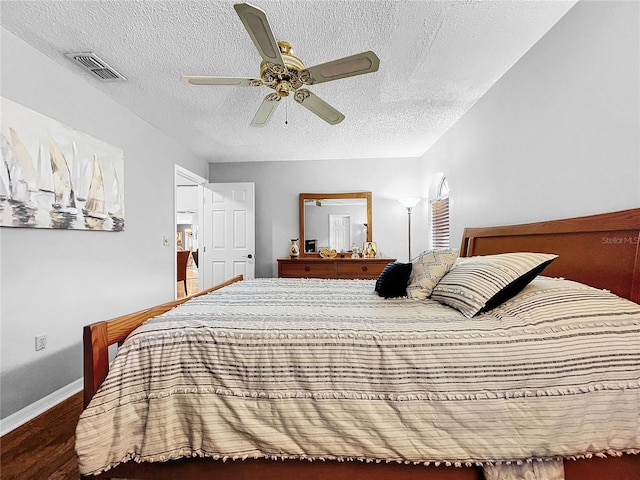 bedroom with baseboards, a textured ceiling, visible vents, and a ceiling fan