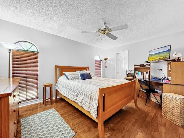 bedroom featuring a textured ceiling, a ceiling fan, and wood finished floors