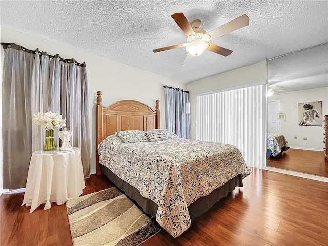 bedroom with a textured ceiling, wood finished floors, a ceiling fan, and baseboards