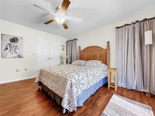 bedroom featuring a textured ceiling, ceiling fan, wood finished floors, baseboards, and a closet