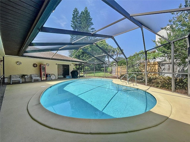 view of pool with a patio and glass enclosure