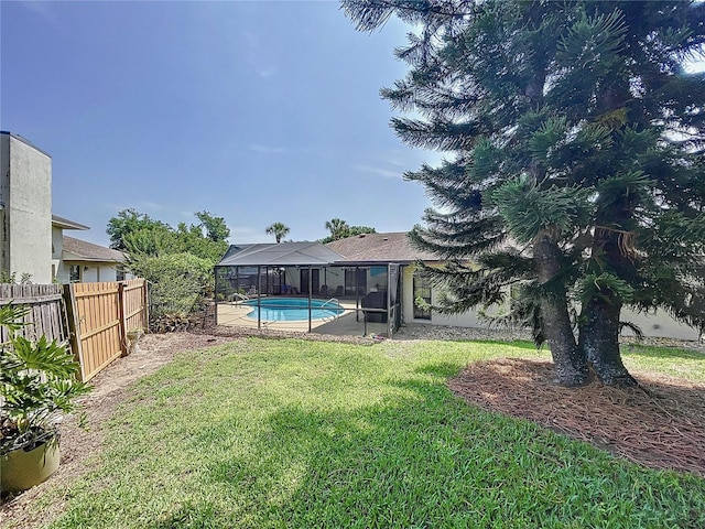 view of yard with a fenced in pool, glass enclosure, fence, and a patio