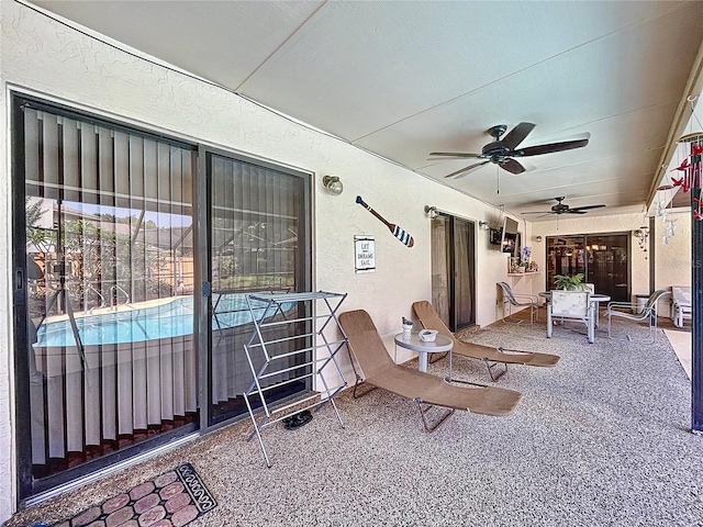 view of patio with an outdoor pool and ceiling fan